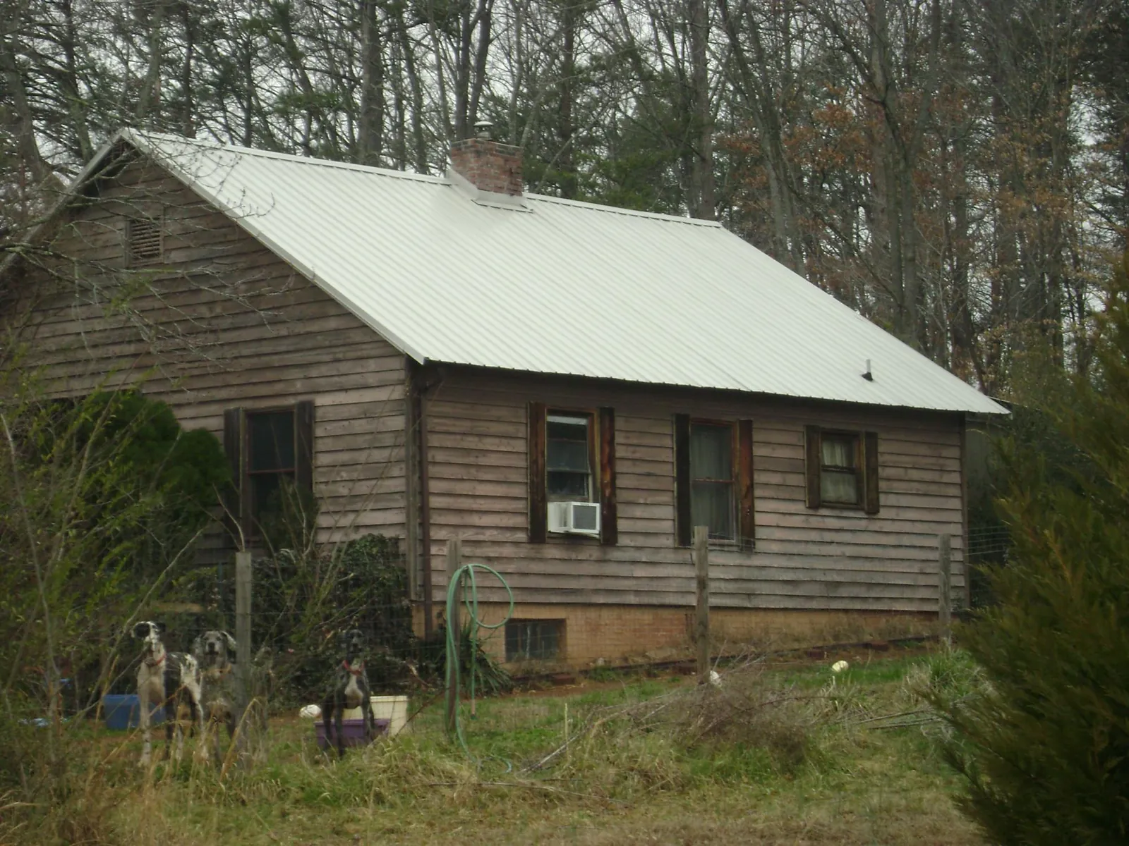 White metal roof on an old wood sided farmhouse, from a Metal Roof Installation job in Piedmont